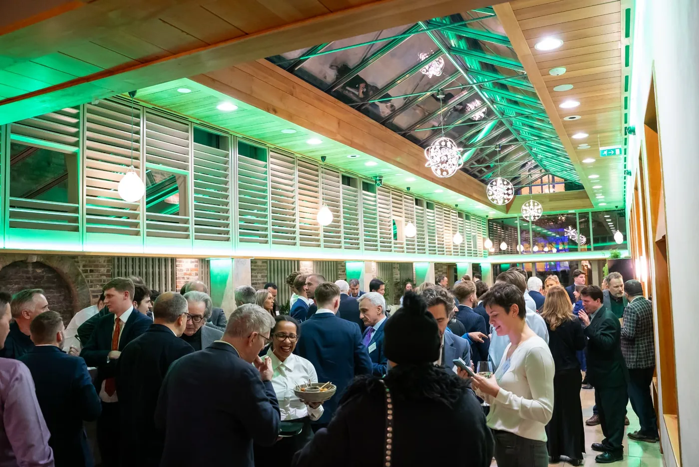 Guests networking at a green-lit Sustainable Wealth Group investor reception
